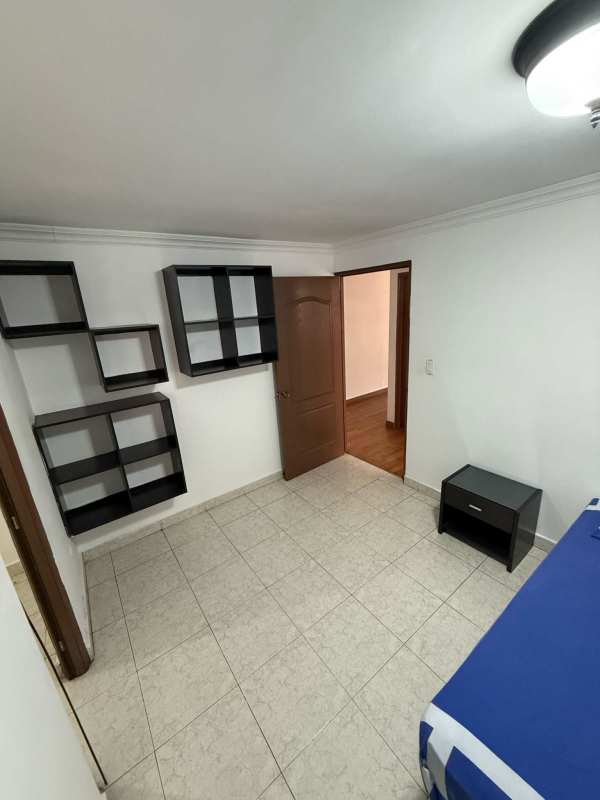Bedroom with shelves, blue bedding, tile floor at PH St Emillion Panama apartment