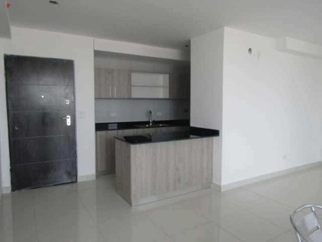 Modern open kitchen design with black countertops and wood cabinetry in PH Carreras El Carmen Panama City