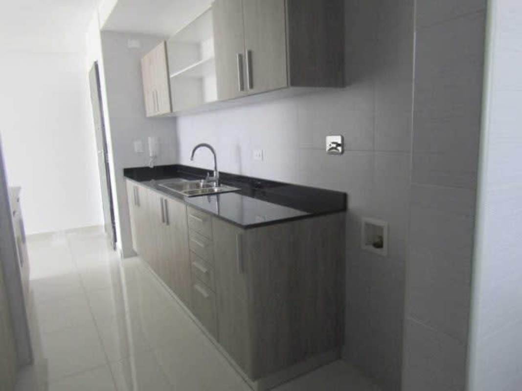 Modern laundry space with window, wood cabinetry, and granite counters in PH Carreras Panama
