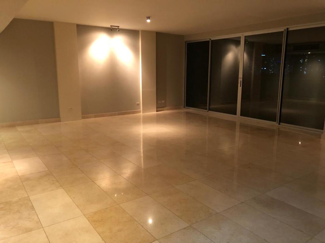 Bright marble floor living room with floor-to-ceiling windows overlooking Parque Omar PH Arboleda Altos del Golf Panama