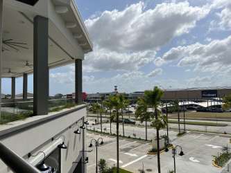 Covered balcony overlooking mall parking and palm trees in Costa Verde La Chorrera Panama