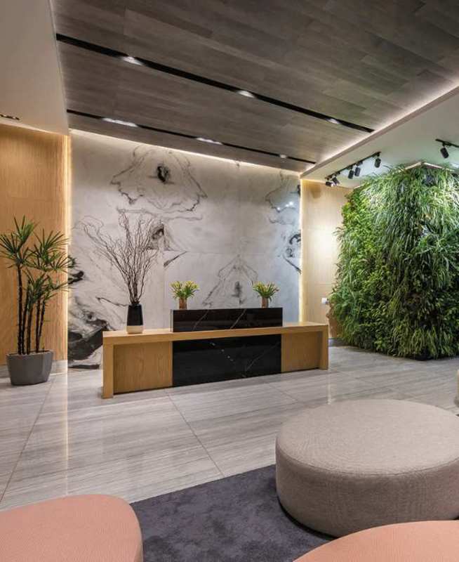 Modern building lobby with vertical gardens, marble finishes and reception desk at PH El Cangrejo Panama