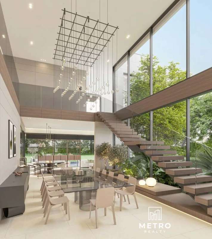 Dining area featuring glass table, floating staircase with glass railing, chandeliers in luxury mansion Panama
