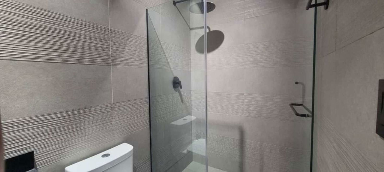 Glass walk-in shower with modern tile finishes Victory Wellness Panama City