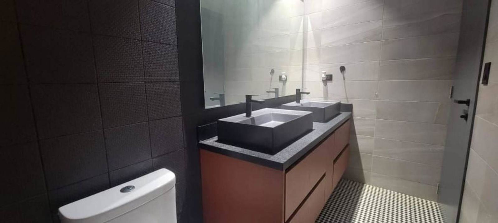 Modern bathroom with double sinks and textured wall tiles Victory Wellness Coco del Mar Panama