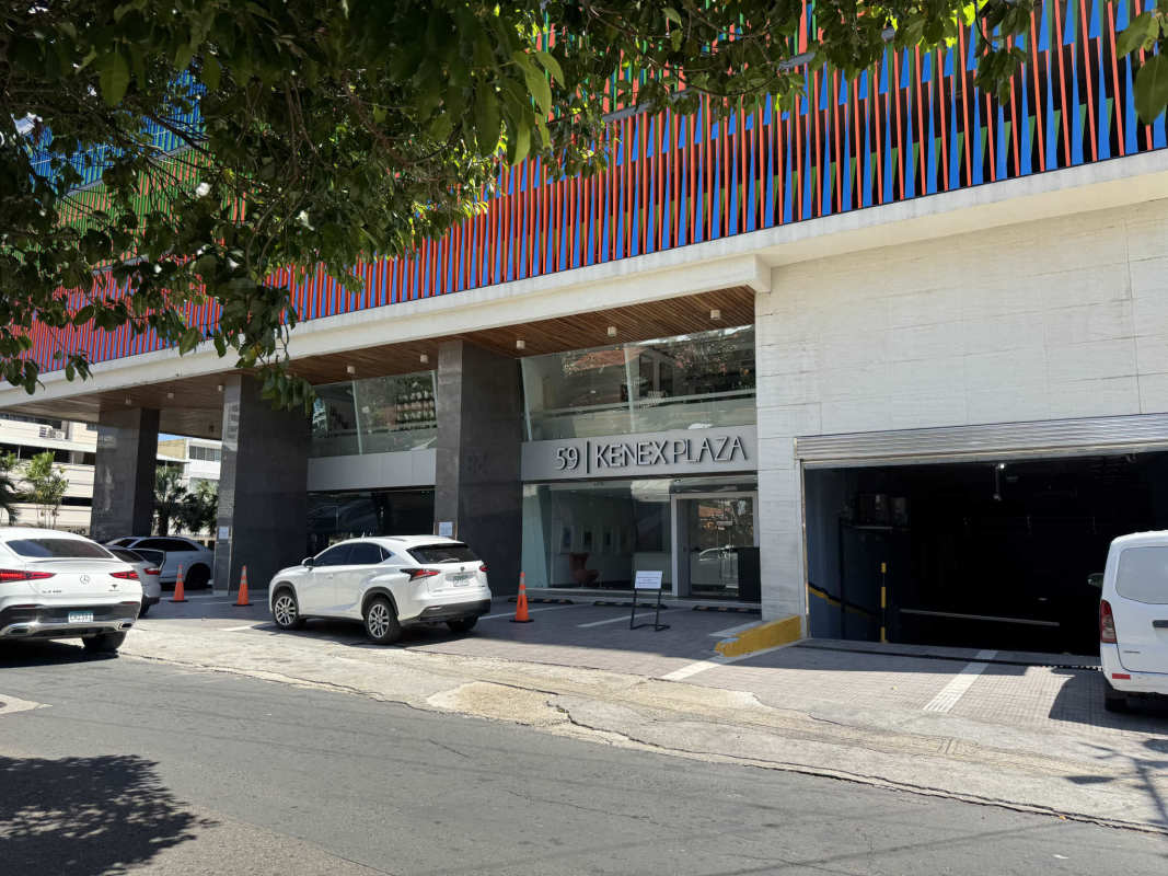 Colorful facade of Kenex Plaza with parking spaces and signage area in Obarrio Panama City