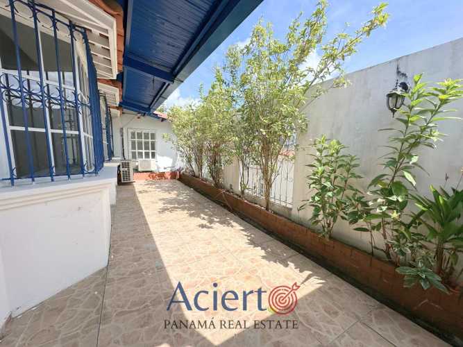 Modern kitchen with granite counters, wood cabinetry, double sink, and appliances