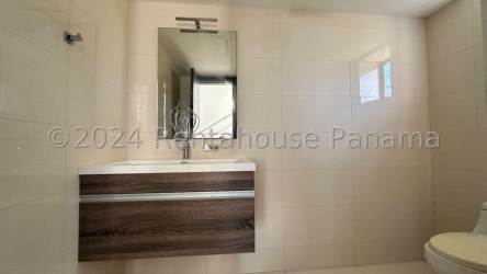 Elegant beige tile bathroom with wall-mounted vanity in San Carlos Panama beach home