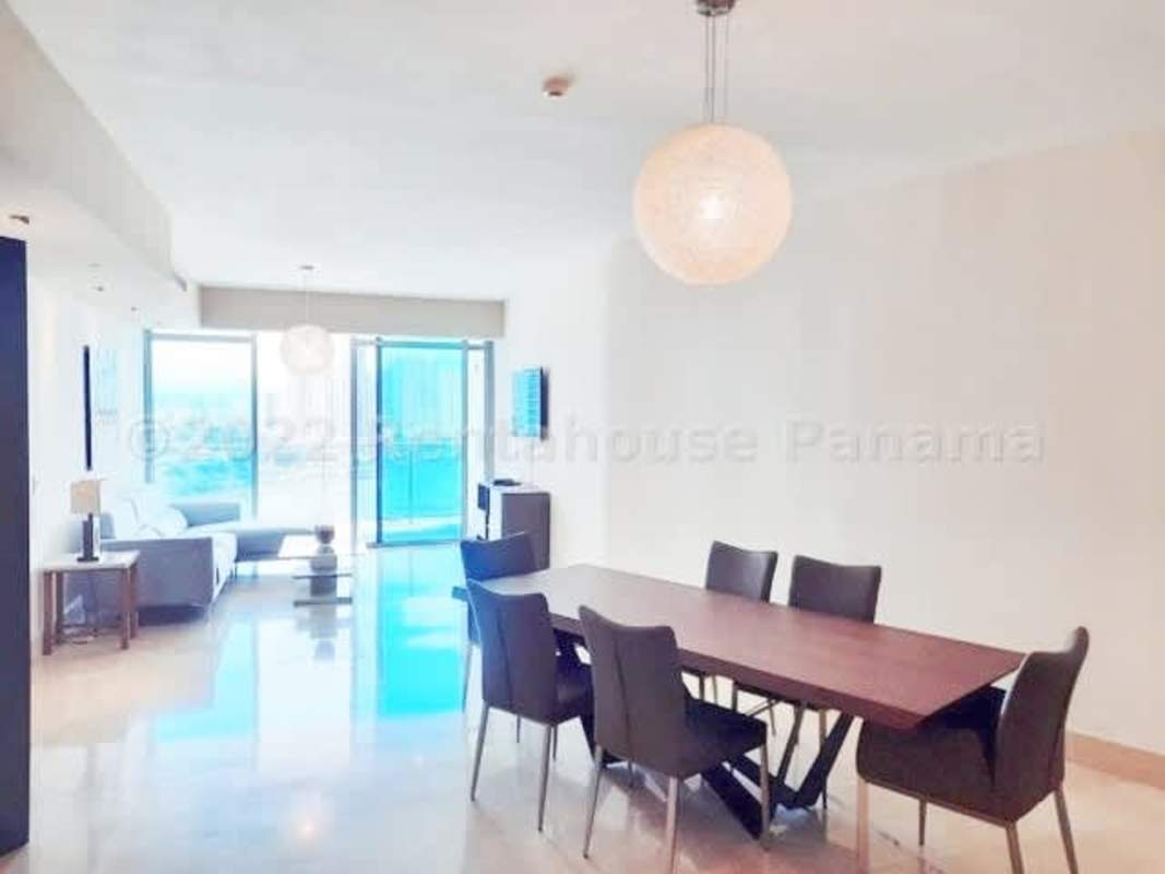 Large open-plan dining and living room with balcony access and panoramic sea views in Grand Tower Punta Pacifica
