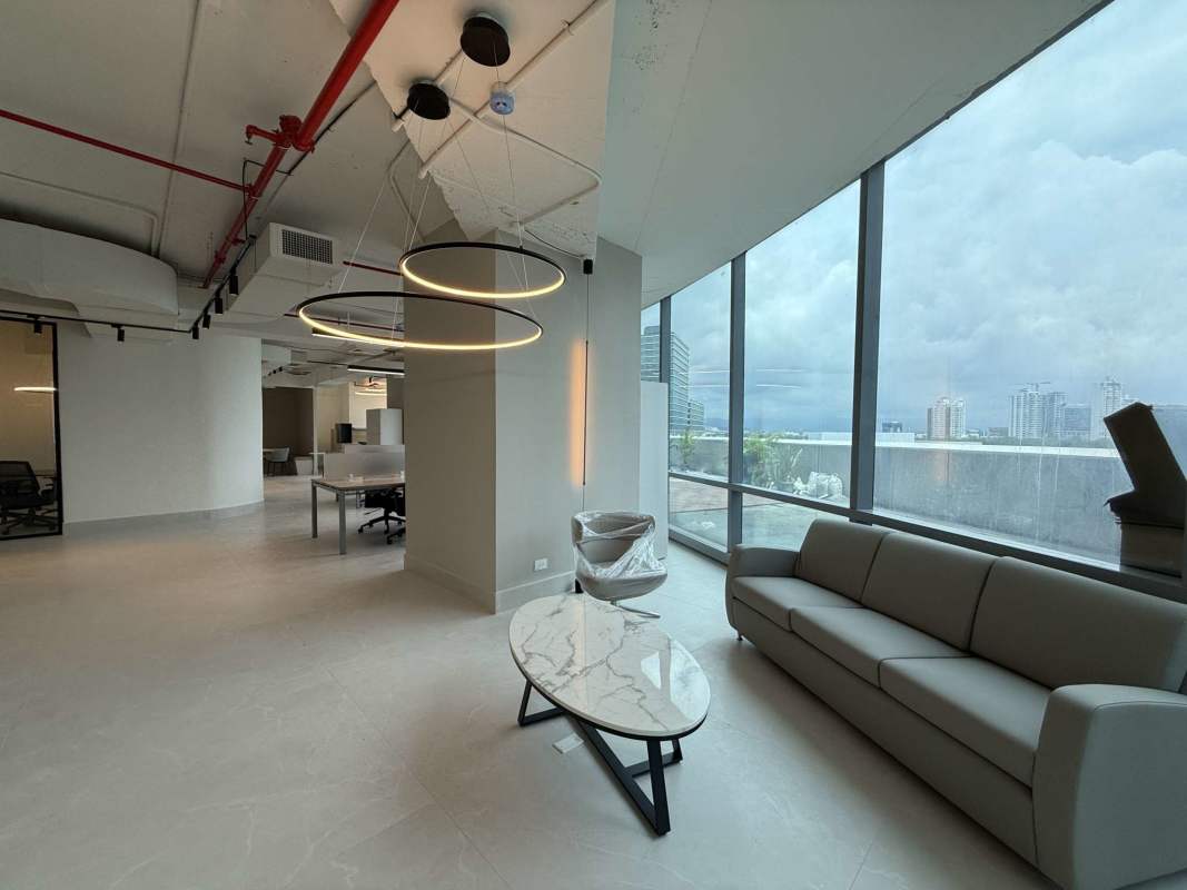 Modern open workspace lounge area with panoramic windows and industrial ceiling in Financial Park