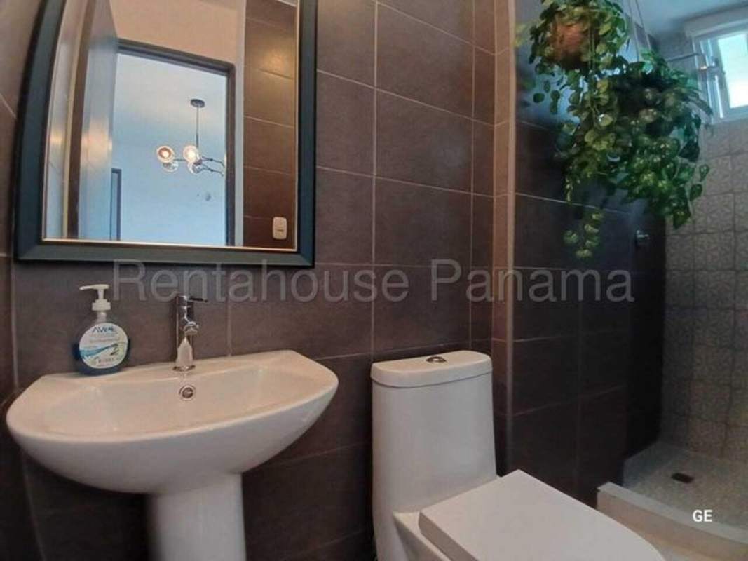 Bathroom with shower, dark tiles, white pedestal sink PH Park Oasis Panama