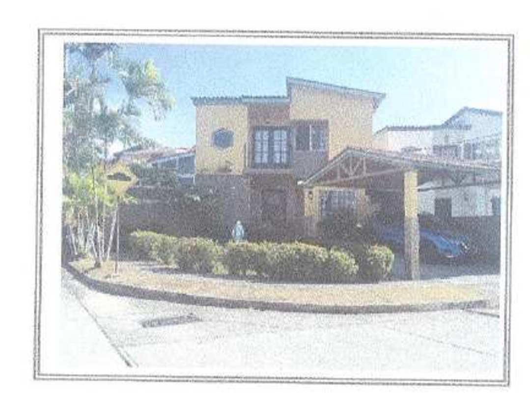 Exterior of two-story duplex house with balcony, covered parking, landscaped yard at Villas de Cerro Lindo Panama