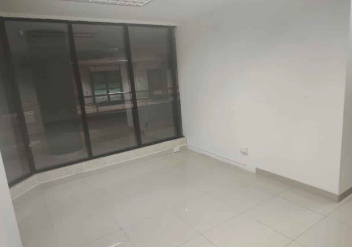 Modern empty office interior with tiled floors, white walls and glass partition at El Dorado Mall Panama