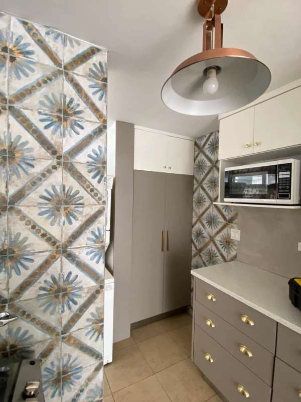 Modern apartment kitchen with patterned backsplash, quartz countertop and microwave in PH Cosmopolitan Panama City