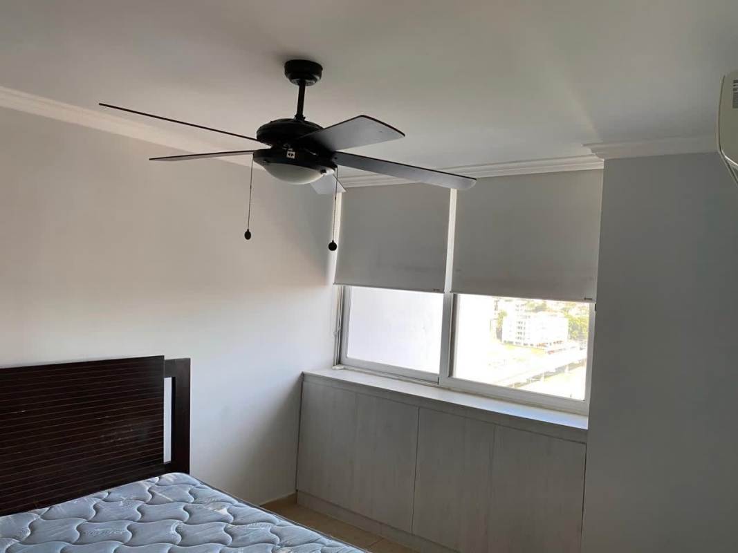 Bedroom with large window, ceiling fan, blinds, and bed in PH Cosmopolitan Tower Panama City