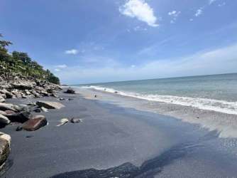 Scenic Pacific beachfront with black sand rocks and ocean at Punta Barco