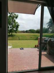 Living room with tile floors, gray sofas, large windows garden views at Decameron Rio Hato