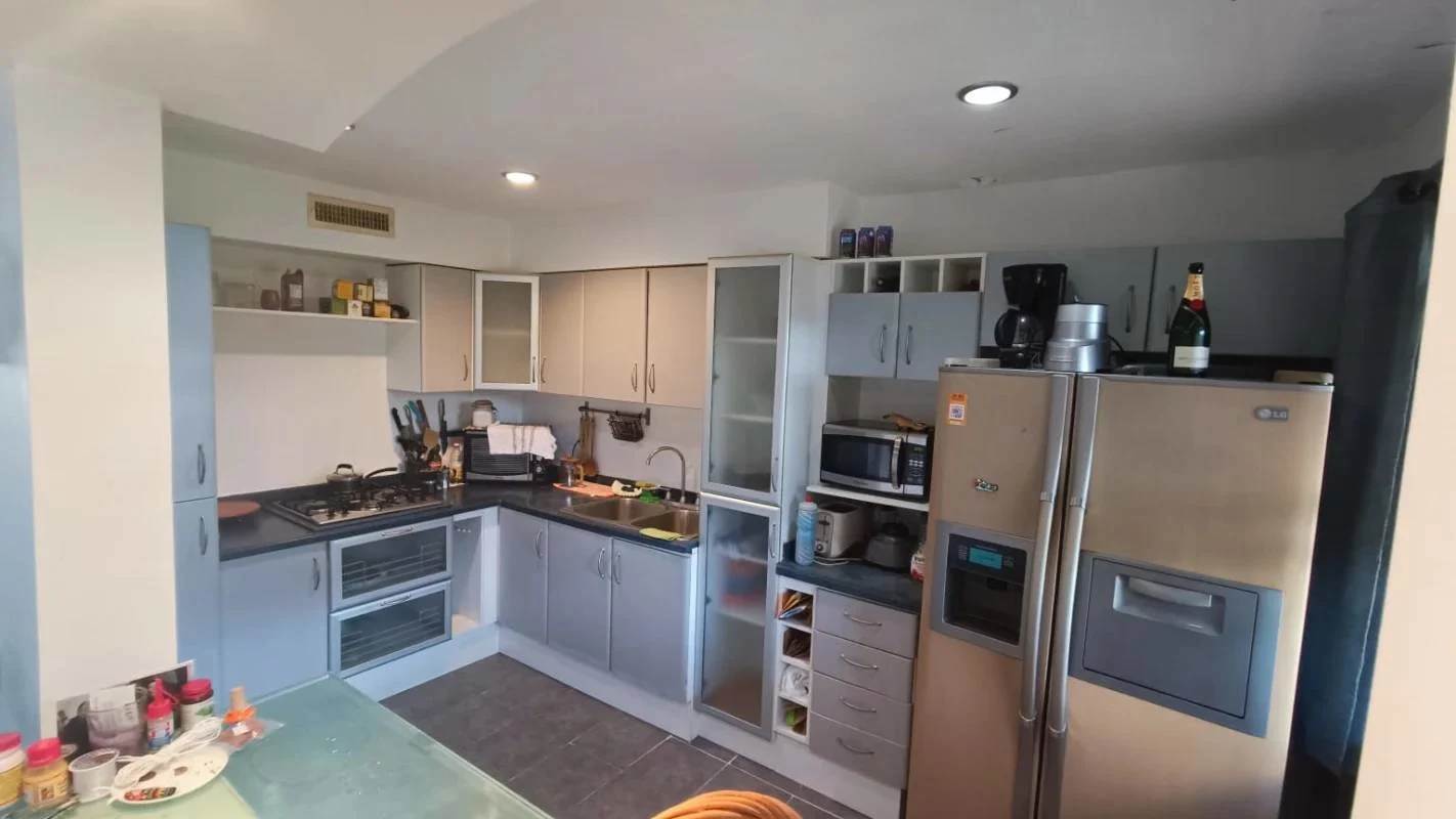 Kitchen with modern appliances, gray cabinetry, and tile flooring in Clayton Panama