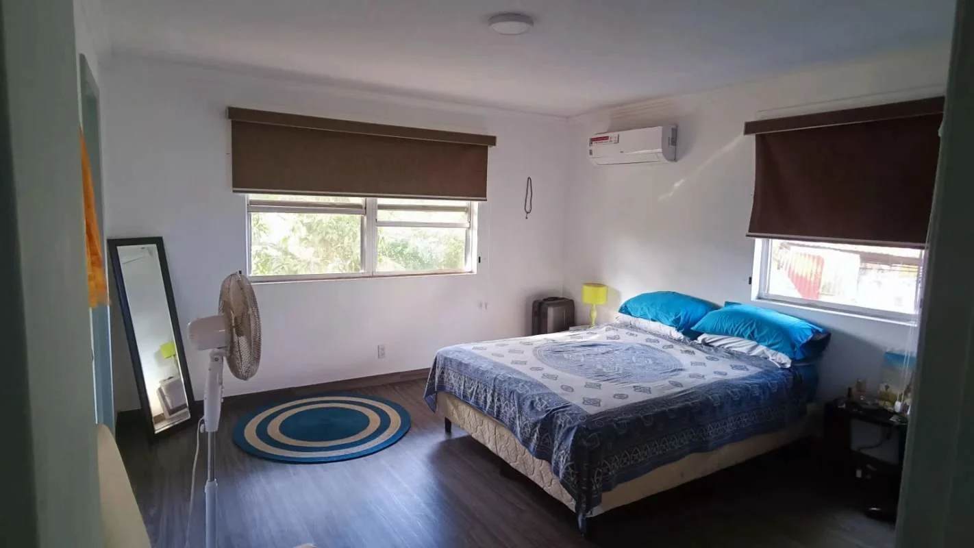 Bedroom with ceiling fan wood floors large window natural light in Clayton Panama
