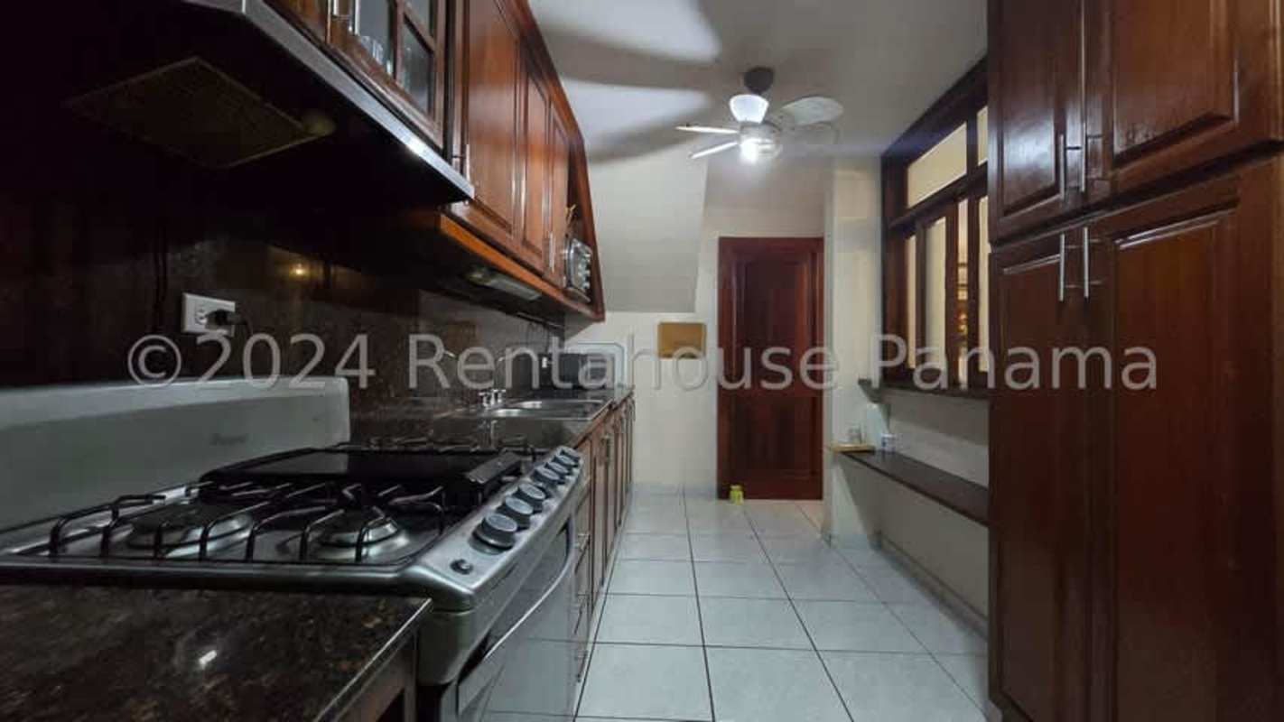 Kitchen with granite countertops, wooden cabinetry and appliances in Condado del Rey Panama house