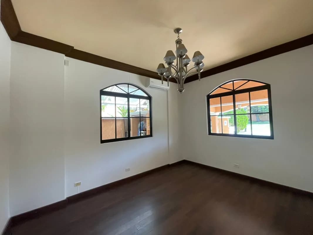 Living room with large windows, ceiling fan, tile floors, neutral tones and view to garden PH Clayton Village Panama