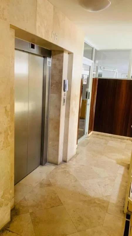 Lobby hallway with elevator and stone wall at PH Canal View Clayton Panama