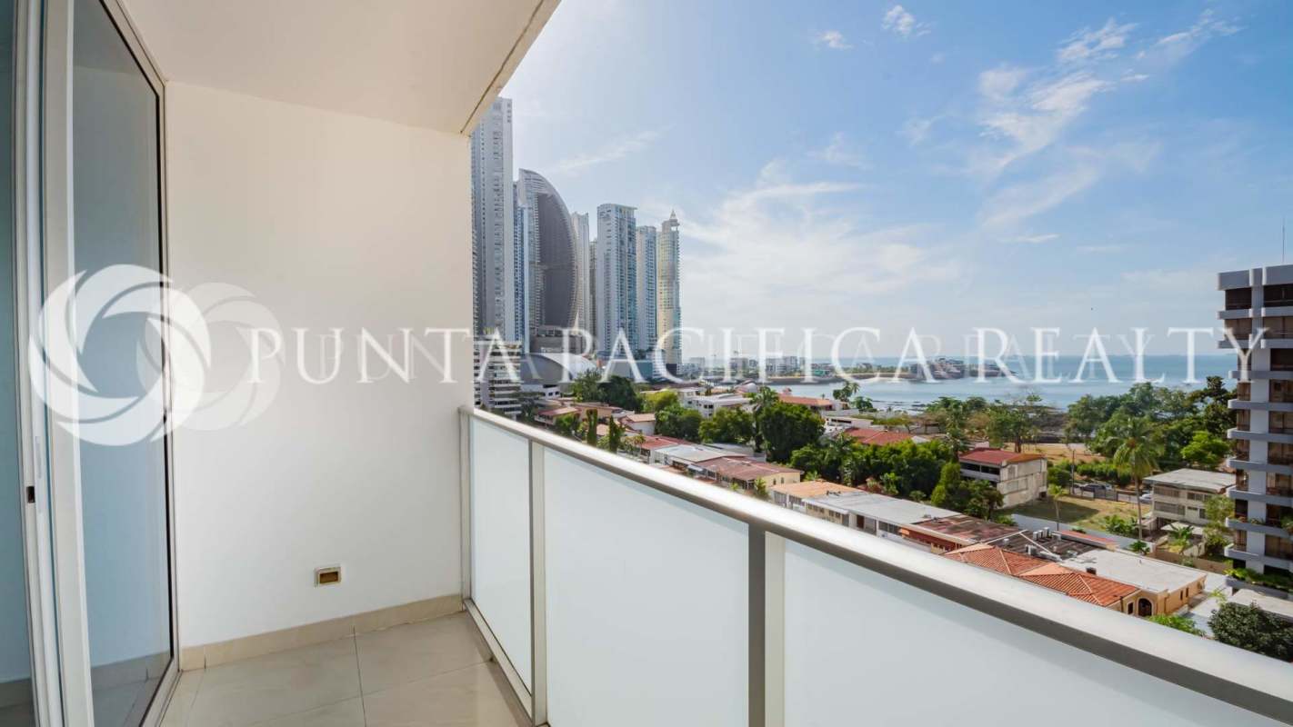 Modern balcony with glass railing overlooking city skyline and Pacific Ocean at PH Pacific Sky