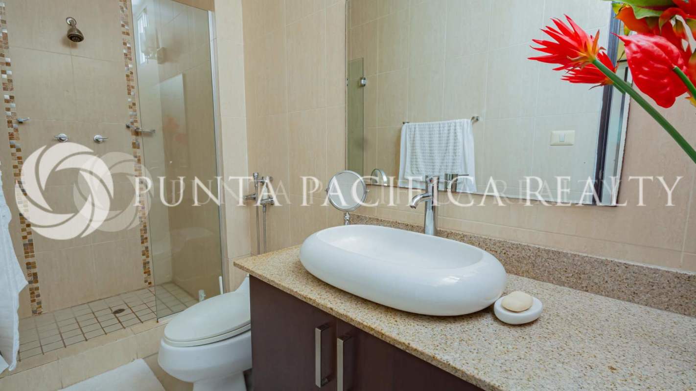 Modern bathroom with vessel sink, large mirror, granite counters in Panama City condo