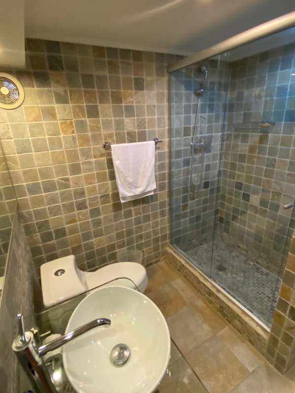 Modern luxury bathroom with vessel sink and glass shower in renovated house Clayton Panama