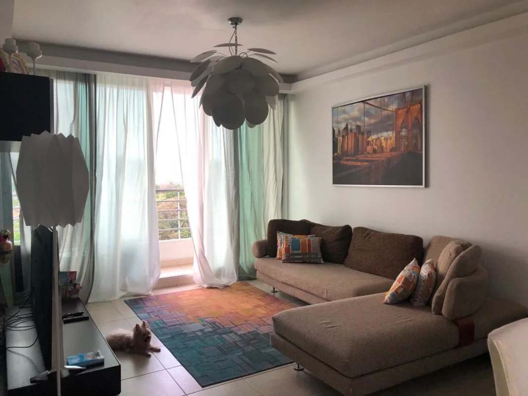 Living room with large windows, sectional sofa, balcony view in PH Clayton Park Panama City