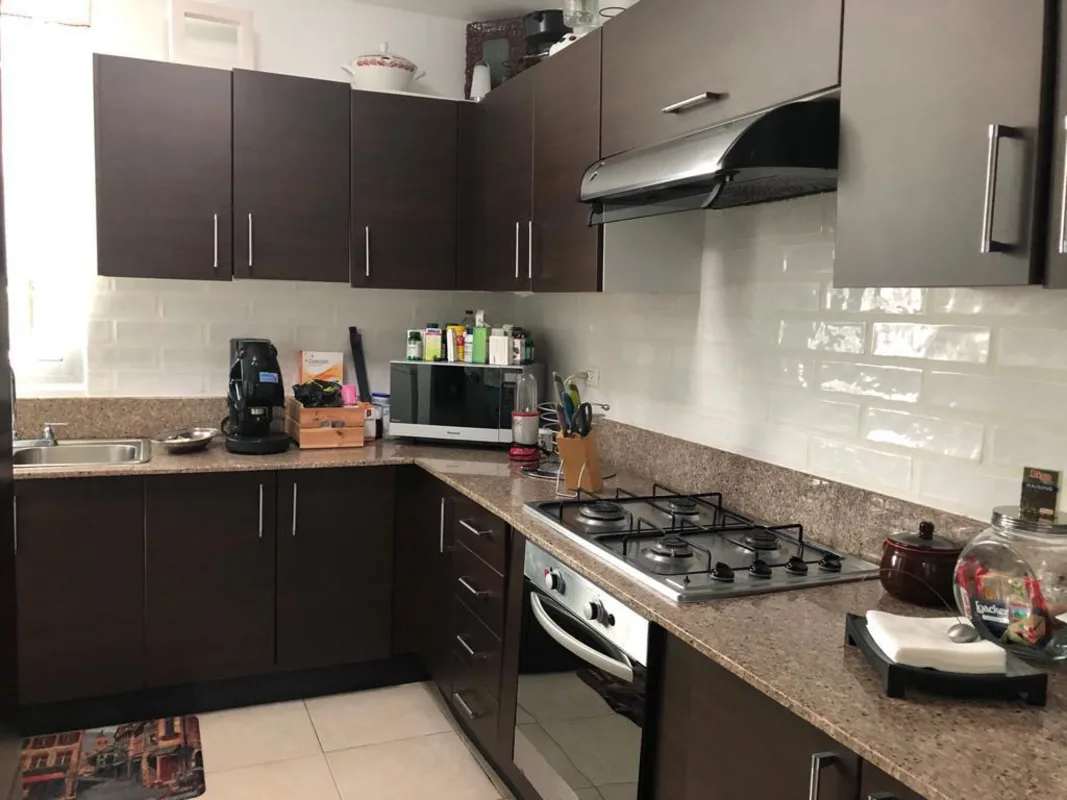 Combined living dining area with large windows, white chairs, sectional sofa in PH Clayton Park Panama