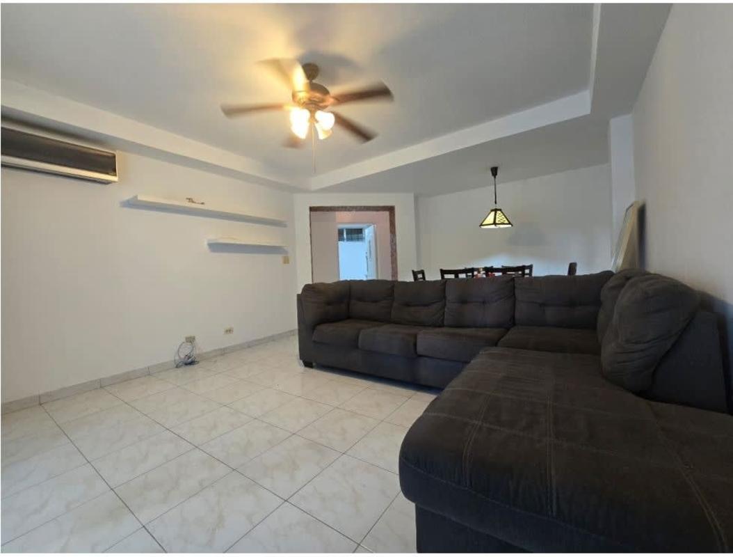 Bright living room with balcony access, AC, and fan, semi-furnished apartment at PH Clayton Tower Clayton Panama