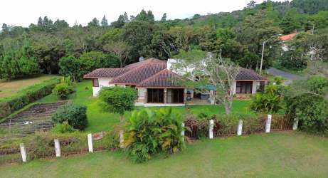 One-story Mediterranean house, landscaped yard, tiled roof and red gate in Volcancito