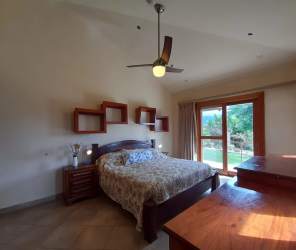 Contemporary living area with fireplace, mounted TV, large windows in mountain home Boquete Panama