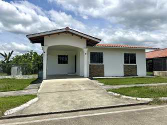 Side of single-family home with driveway covered carport and fencing in Boquerón Panama