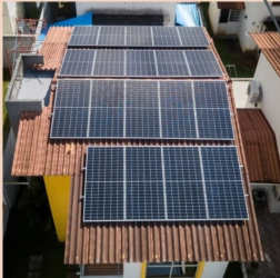 Terracotta-tiled roof with multiple solar panels on duplex house Residencial Santillana Arraiján