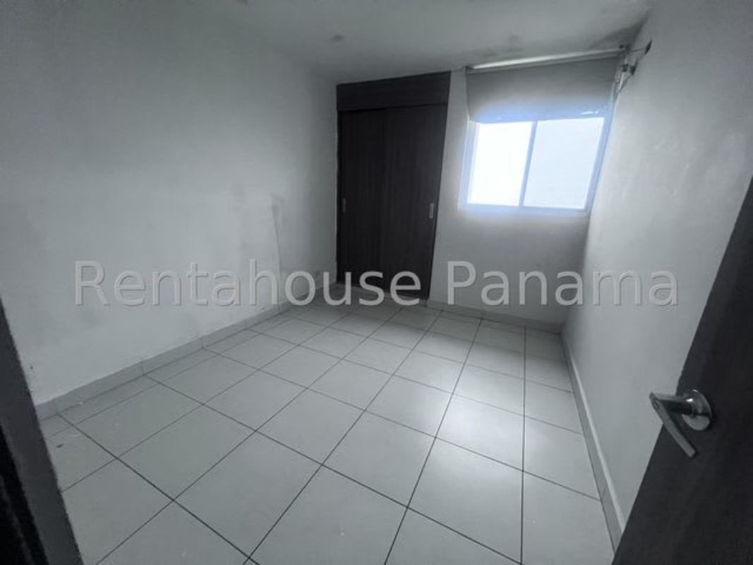 Minimalist design bathroom with white tile, walk-in shower, and natural light in Panama apartment