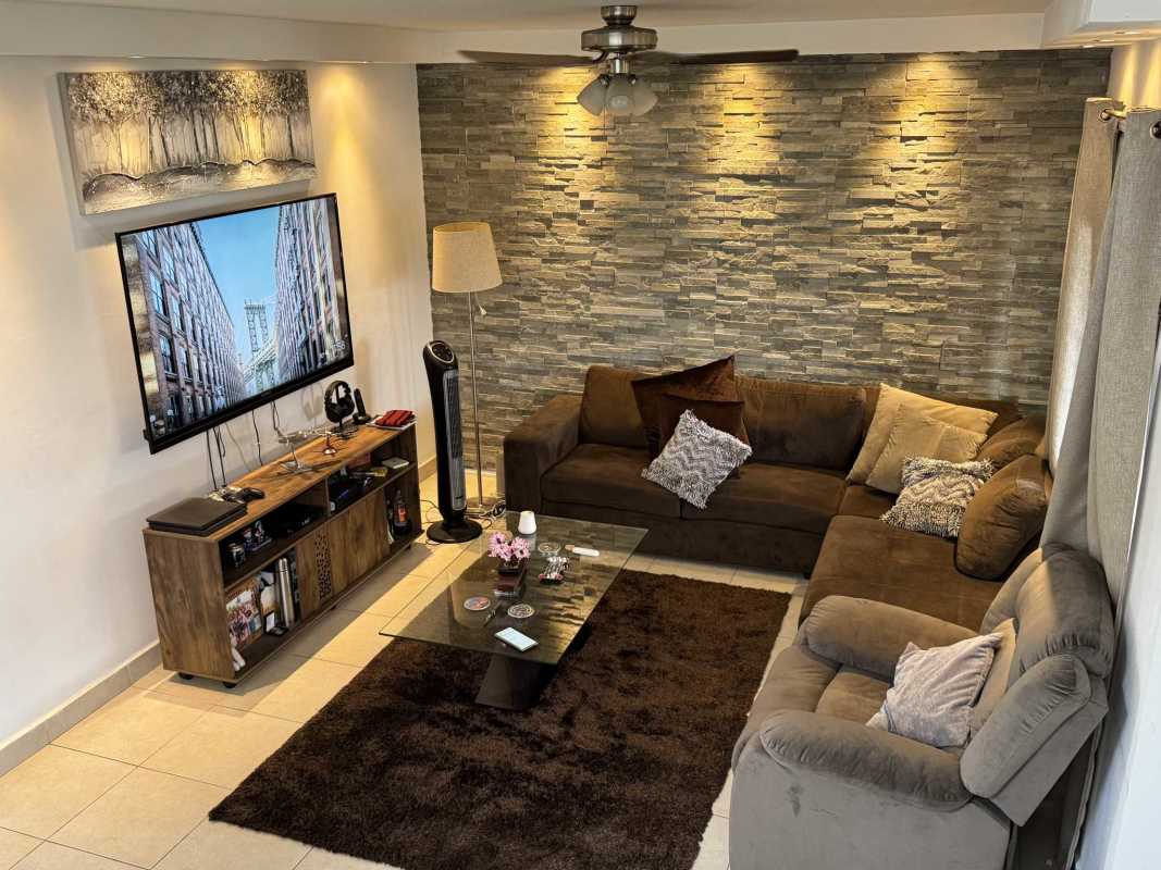 Bright open living area with wood floor accent and ceiling fan in Versalles House Costa Sur Panama