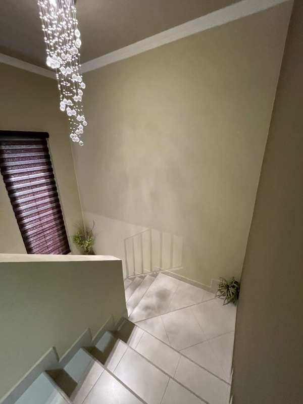 Stairwell with crystal chandelier, neutral colors, and daylight in modern Panama house