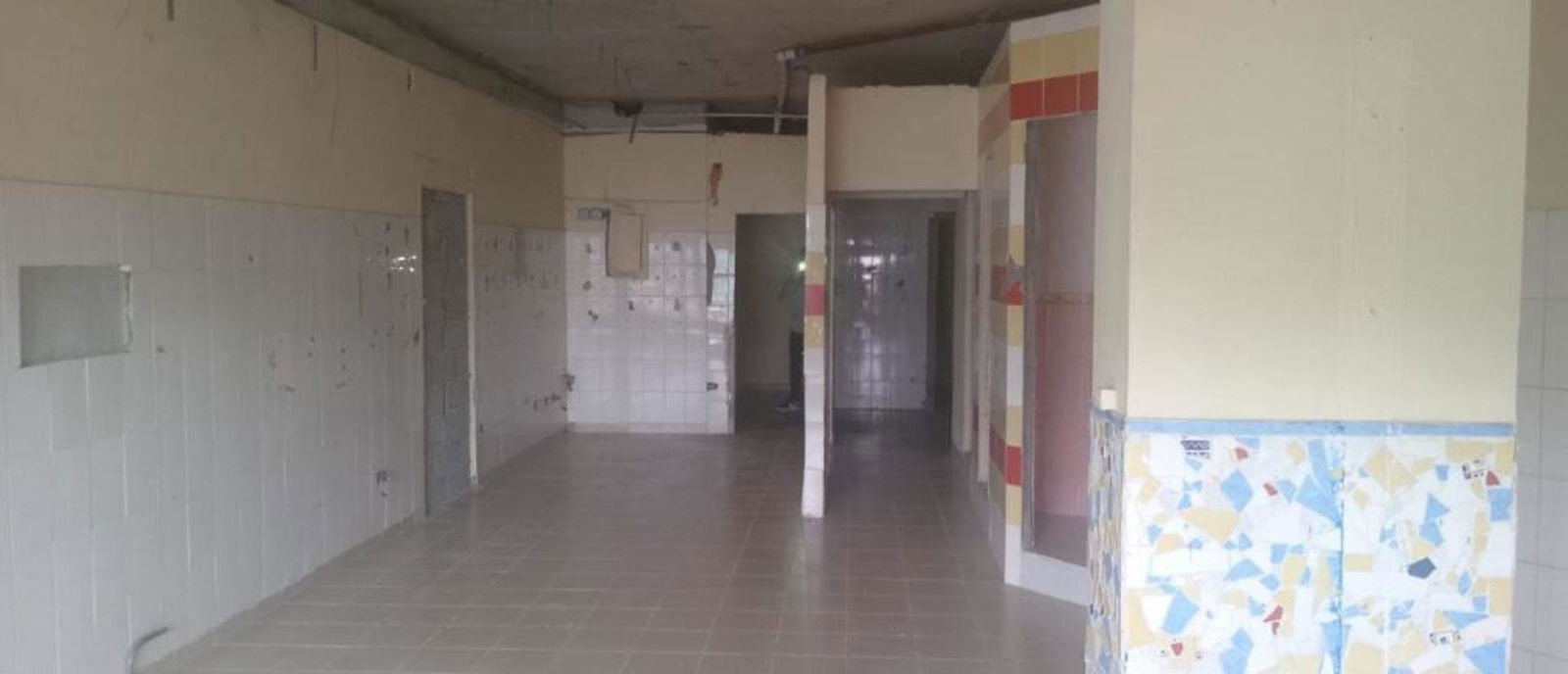 Large unfinished commercial interior space with tiled walls and exposed ceiling in Rio Abajo available for rent