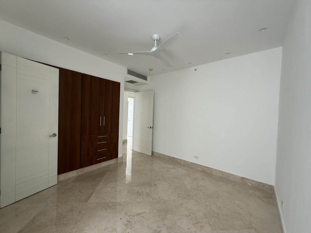 Bright master bedroom with marble floors and wraparound ocean view windows in PH The Point Panama City