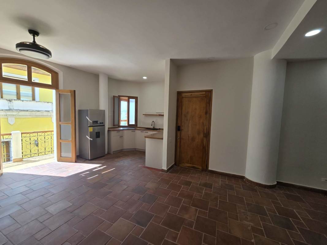 Living room with terracotta floor, wood accents, ceiling fans and balcony access in Casco Viejo rental apartment Panama