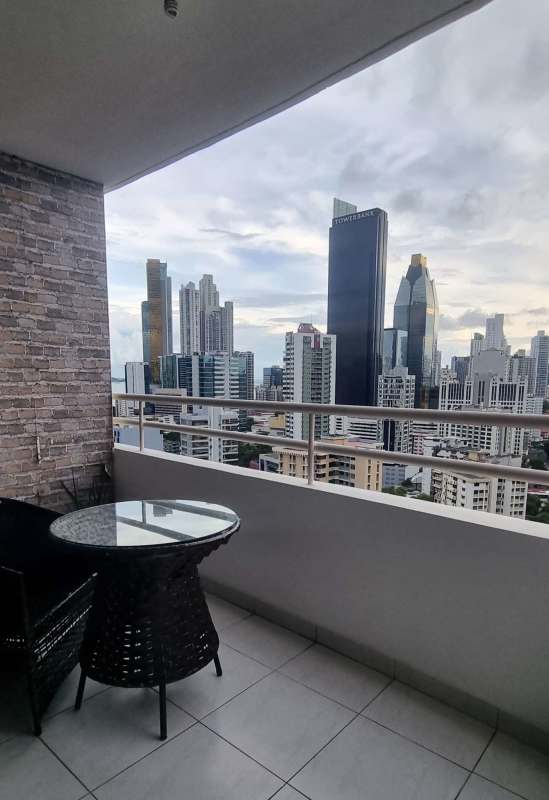 Minimalist bedroom with office chair, large window showing Panama City skyline in PH Obarrio Tower