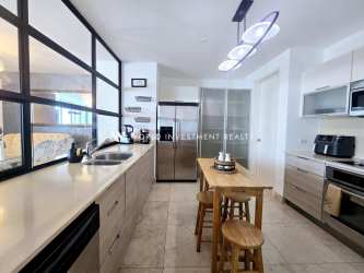 Open kitchen island with marble floors and stainless steel appliances at PH Casa Bonita Panama