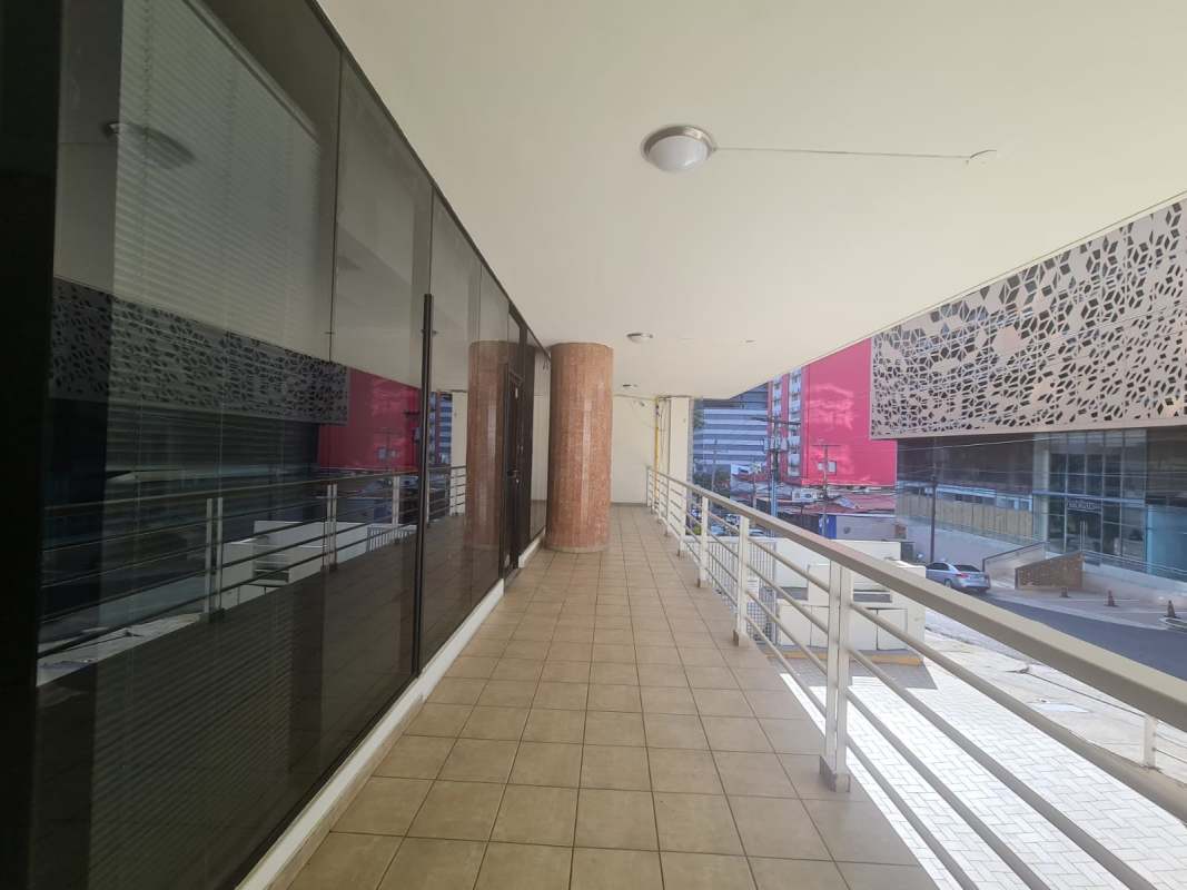 Covered exterior passage with railings and palm plants at Obarrio Commercial Center Panama City