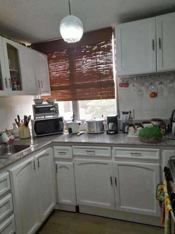 Large bedroom with ceiling fan, wooden bed, recliner chair in PH El Dorado Park Tower Panama City