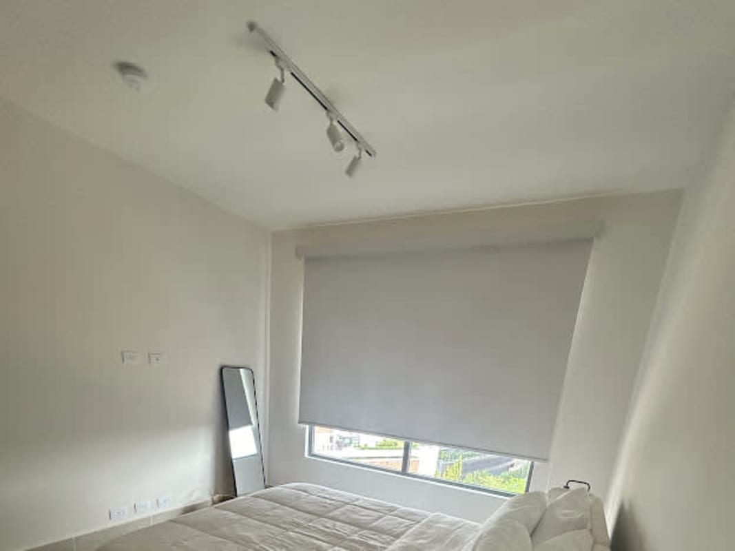 Bright guest bedroom with panoramic windows overlooking Panama City skyline Santa Maria Golf apartment