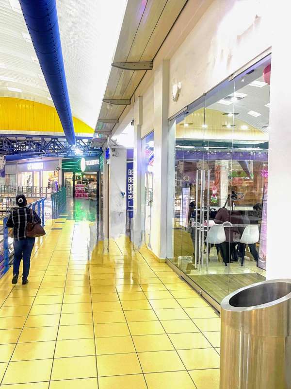 Wide commercial corridor interior with glass storefronts at Albrook Mall Panama