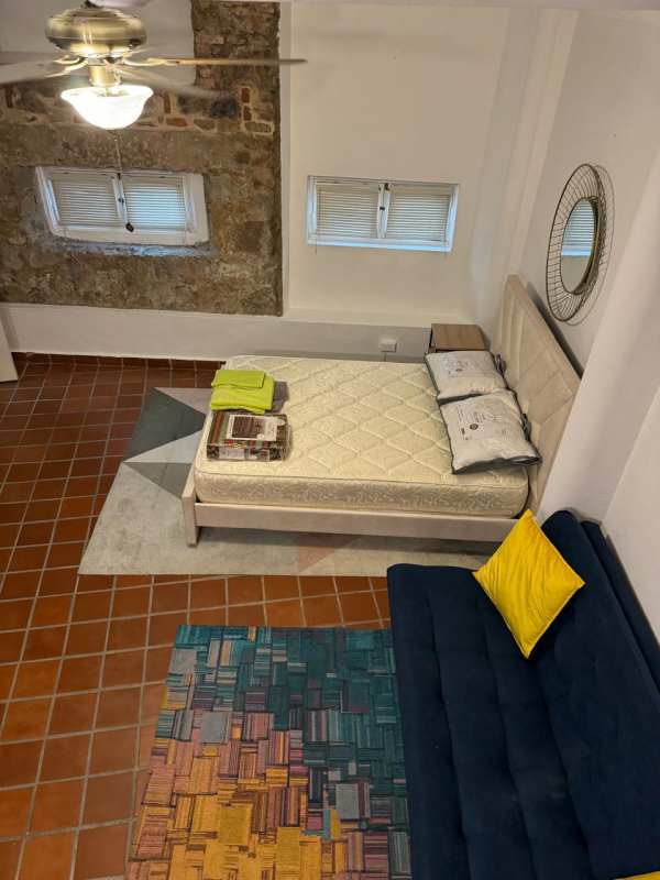 Living room with pink spiral staircase stone accent wall terracotta floors Casco Viejo