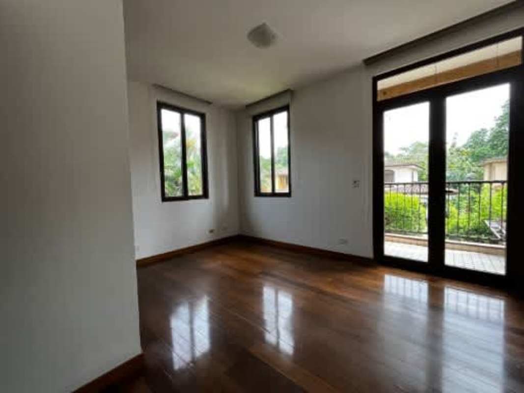 Bedroom with wooden floors, balcony and green view Embassy Club Clayton home